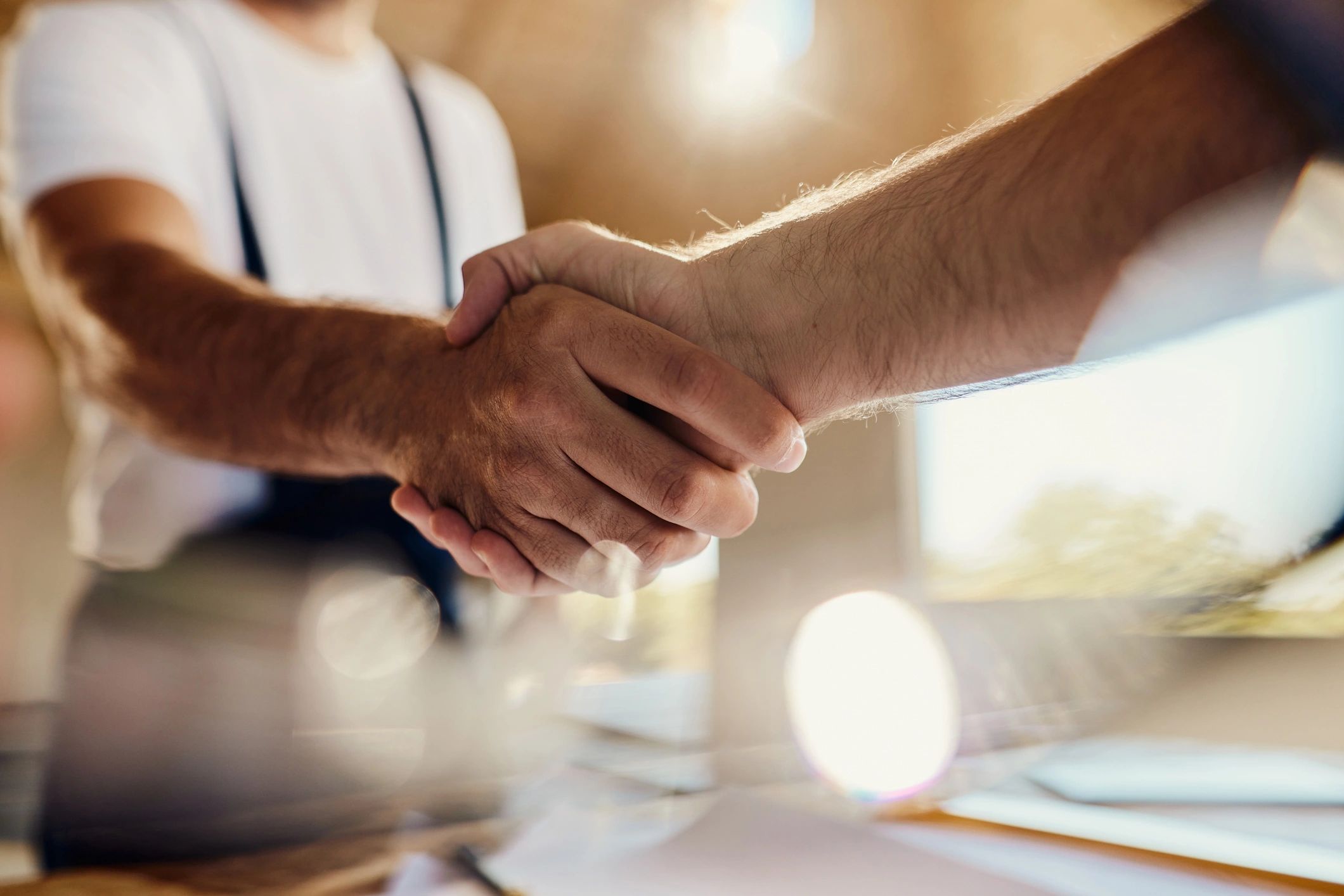 Two professionals shaking hands to represent partnership
